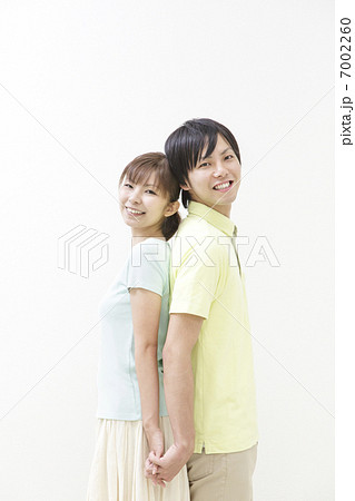 背中合わせで立つ日本人のカップルの写真素材