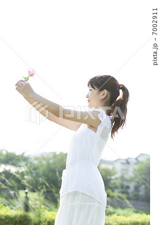一輪の花を持つ女性の写真素材