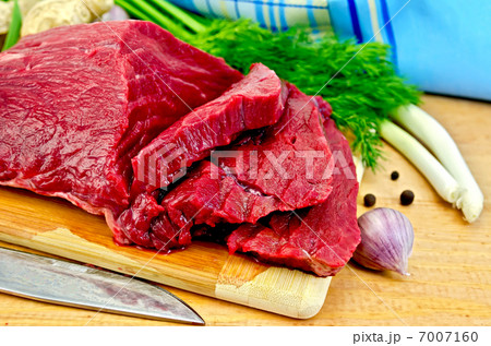 Meat beef on a wooden board with a knife Meat beef on a wooden board with a knife 7007160