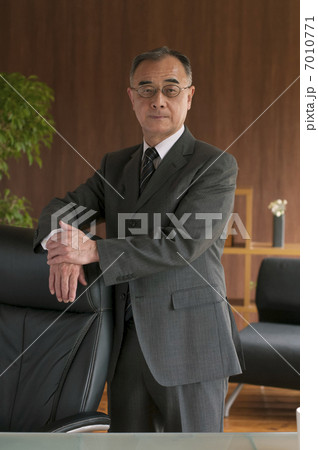椅子に手をかけるビジネスマンの写真素材