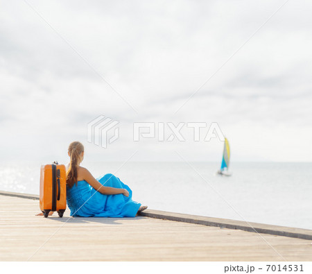 Young woman sitting on wooden pier Young woman sitting on wooden pier 7014531