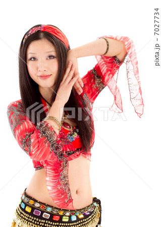 真っ赤なベリーダンスの衣装を着て笑顔で踊る若い女性 7027734