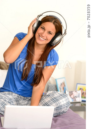 Cheerful teenager girl listening music headphones Cheerful teenager girl listening music headphones 7028359