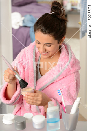 Teenager girl applying make-up powder with brush 7028375