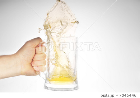 Hand holding mug with splashing beer 7045446