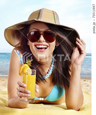 Girl in bikini drinking alcohol coctail through a straw. Girl in bikini drinking alcohol coctail through a straw. 7051997