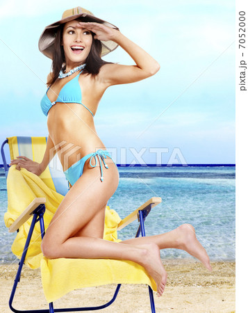 Girl in bikini drinking alcohol coctail through a straw. 7052000