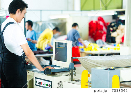 Worker on a machine in asian factory 7053542
