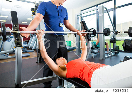 woman and Personal Trainer in gym 7053552