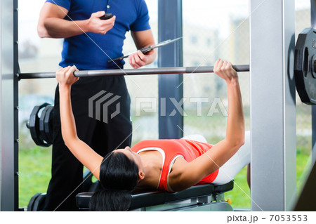 woman and Personal Trainer in gym 7053553