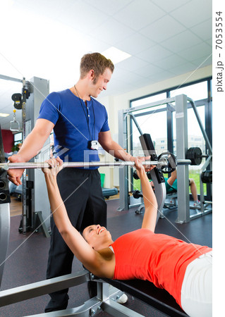 woman and Personal Trainer in gym 7053554