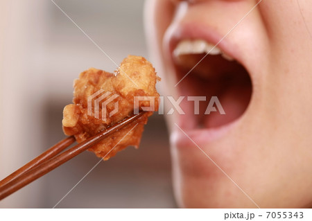 唐揚げを食べる女性の口元 7055343