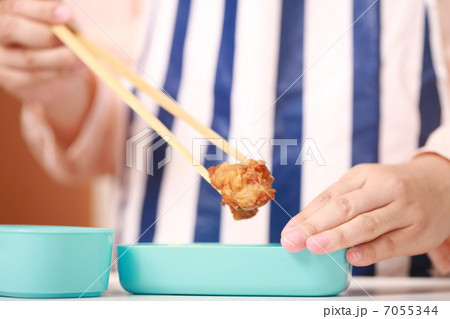 お弁当箱に唐揚げを詰める母親の手元 7055344