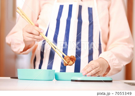 お弁当箱に唐揚げを詰める母親の手元 7055349