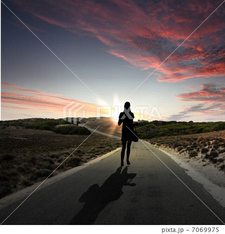 Man walking away at dawn along road Man walking away at dawn along road 7069975