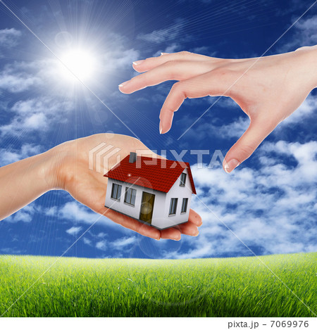 House and human hand against blue sky 7069976