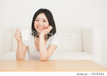部屋でマグカップを持つ女性 7076361