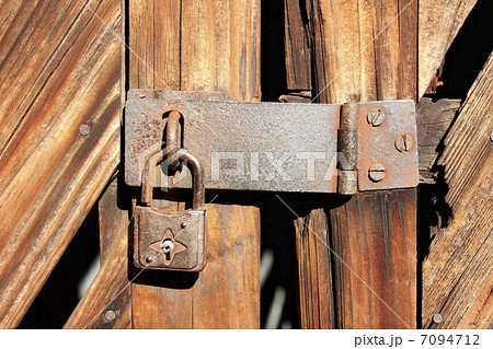 古い倉庫の木製扉の錆びた鍵の写真素材