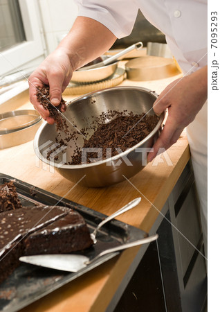 Chef decorating chocolate cake with icing sugar 7095293