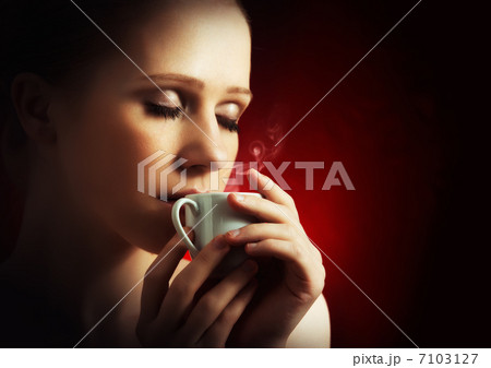sexy woman enjoying a hot cup of coffee on a dark background 7103127
