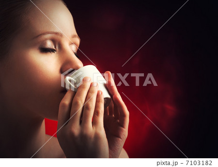 sexy woman enjoying a hot cup of coffee on a dark background 7103182