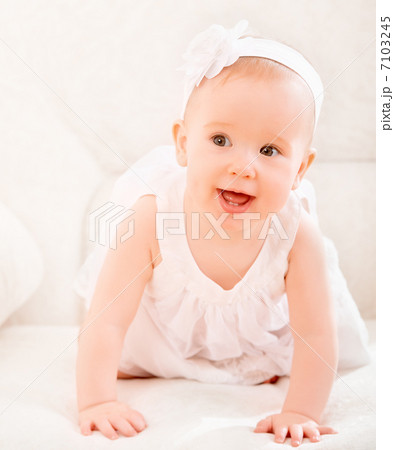 little cute girl in a white dress and with flower smiling 7103245