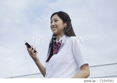 スマートフォンで音楽を聞く女子高生 7104561