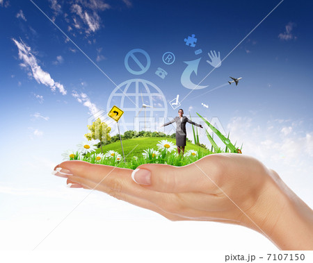 Human hand holding a green landscape 7107150