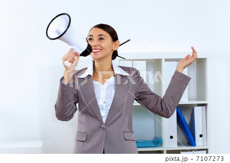 Young woman with megaphone in office Young woman with megaphone in office 7107273
