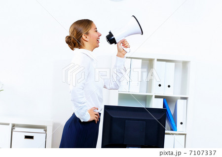 Young woman with megaphone in office Young woman with megaphone in office 7107337