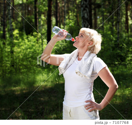 elderly woman after exercising in the forest 7107768