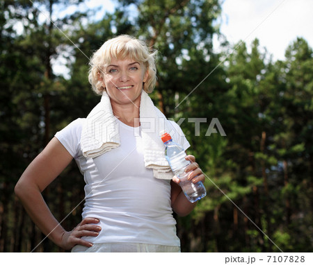 elderly woman after exercising in the forest elderly woman after exercising in the forest 7107828