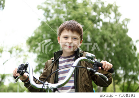 Boy on a bicycle in the green park Boy on a bicycle in the green park 7108393