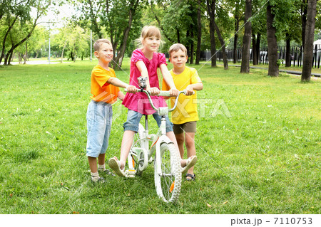 Girls with a bike in the park Girls with a bike in the park 7110753