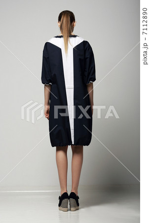 Rear View of of Trendy Chichi Woman in White-Black Contrast Raincoat. Vogue Rear View of of Trendy Chichi Woman in White-Black Contrast Raincoat. Vogue 7112890