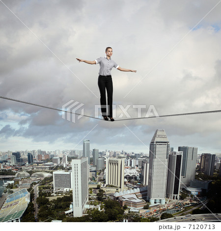 Balancing businesswoman and cityscape Balancing businesswoman and cityscape 7120713