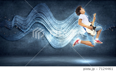 young man playing on electro guitar and jumping young man playing on electro guitar and jumping 7124461