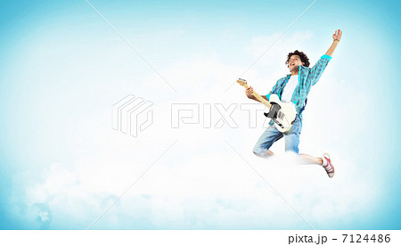 young man playing on electro guitar and jumping young man playing on electro guitar and jumping 7124486