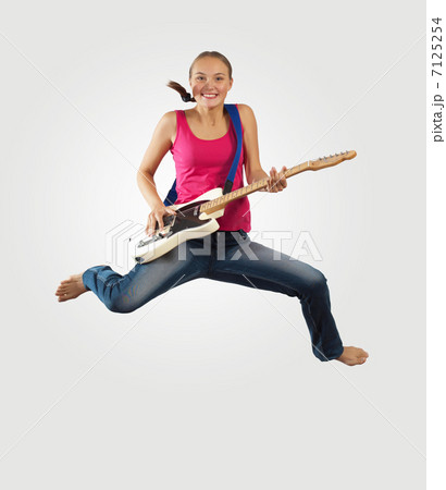 young woman playing on electro guitar and jumping 7125254
