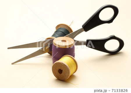 Thread bobbin and scissors on the white background 7133826