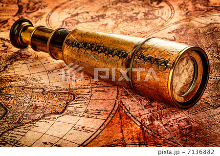 Vintage spyglass lies on an ancient world map Vintage spyglass lies on an ancient world map 7136882