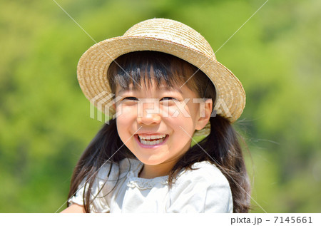 笑顔の女の子 横顔 麦わら帽子 の写真素材