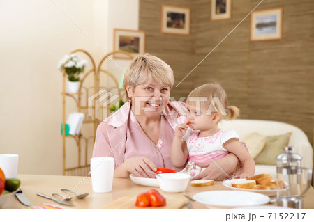 grandmother feeding granddaughter at home grandmother feeding granddaughter at home 7152217