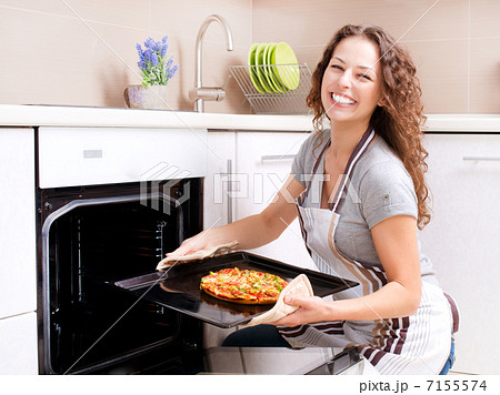 Happy Young Woman Cooking Pizza at Home 7155574