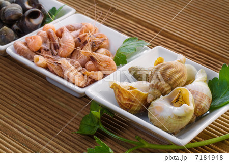 Sea shells with herbs on a wooden background 7184948