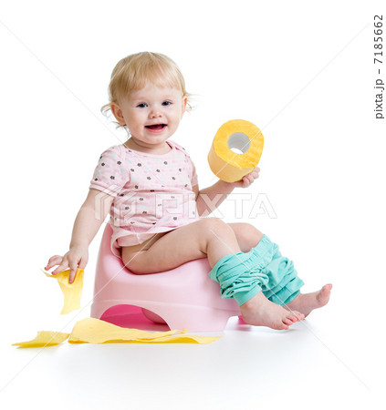 smiling baby sitting on chamber pot with toilet paper roll 7185662