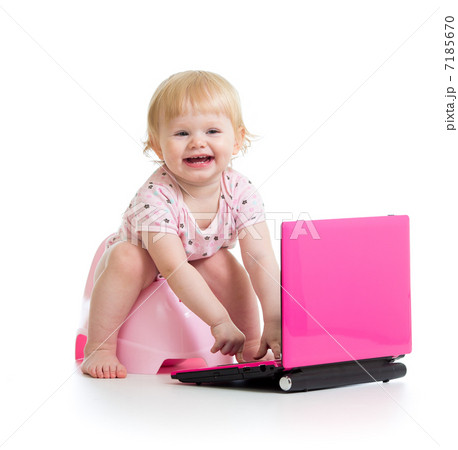 baby girl sitting on chamberpot with notebook 7185670