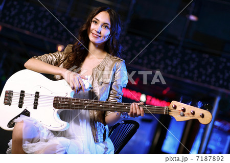 Young guitar player performing in night club 7187892