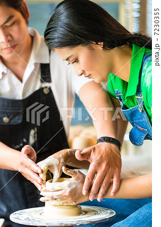 Potter creating clay bowl on turning wheel 7230355
