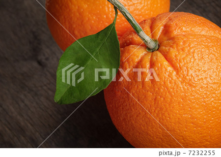 ripe round orange with stem and leaf on wooden table 7232255